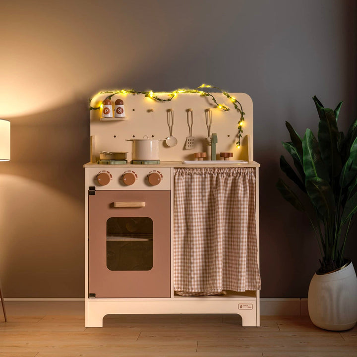 Rustic Wooden Kitchen with Cooking Utensils, Pans, Apron, Gloves and Leaf Light String - Chic Petit
