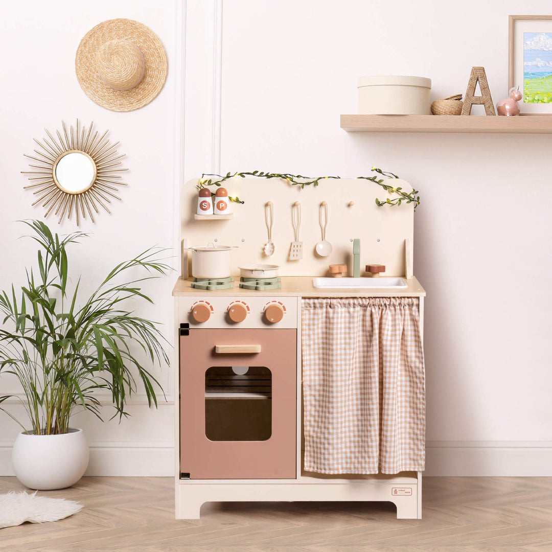 Rustic Wooden Kitchen with Cooking Utensils, Pans, Apron, Gloves and Leaf Light String - Chic Petit