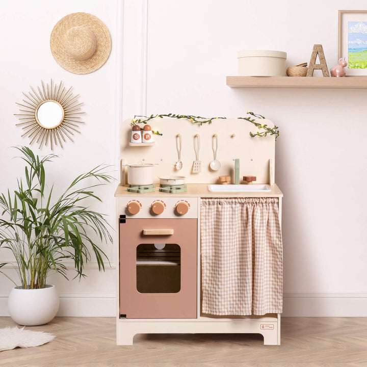 Rustic Wooden Kitchen with Cooking Utensils, Pans, Apron, Gloves and Leaf Light String - Chic Petit